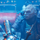 a man with an eyepatch and a leather jacket sits at a dingy bar in the ascent for xbox game pass